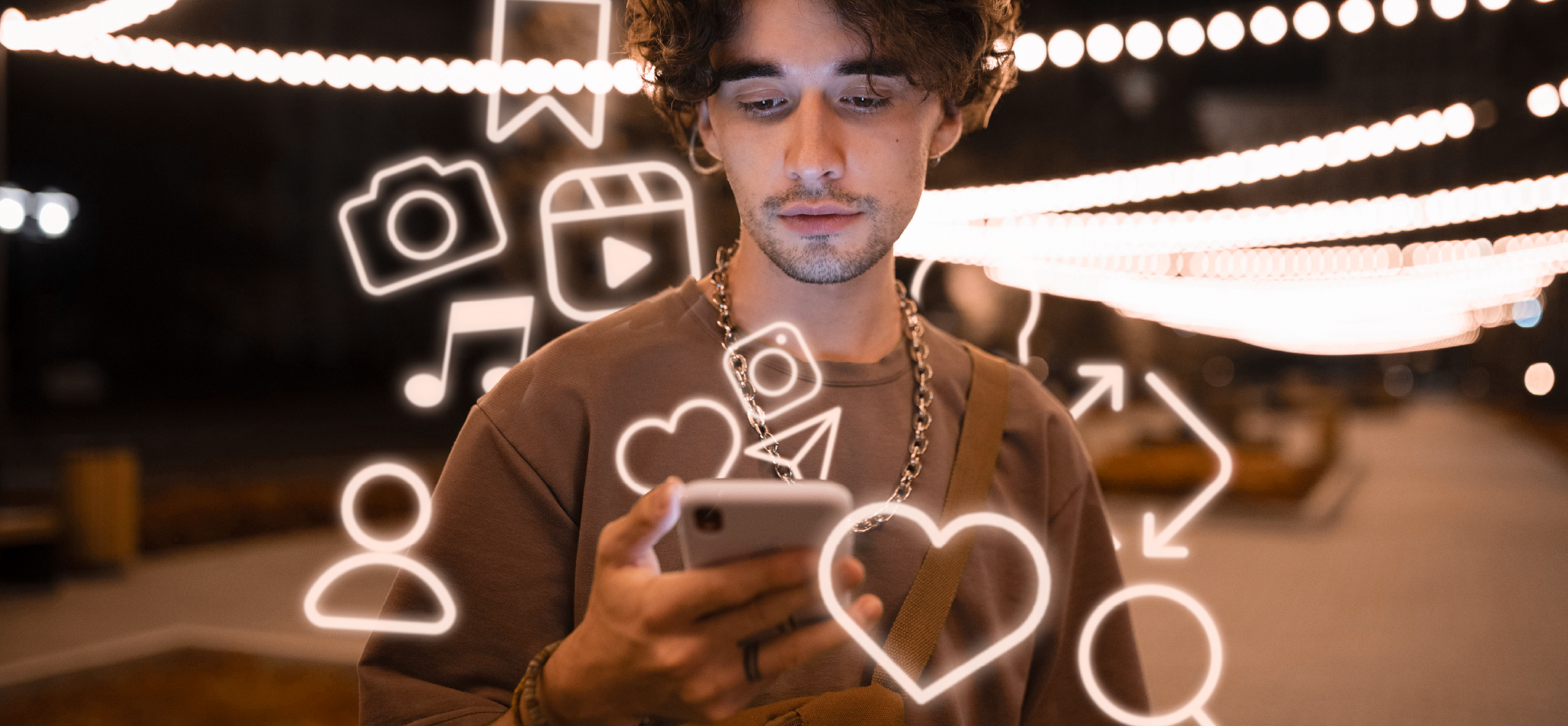 Personne tenant un smartphone avec des emojis lumineux tout autour